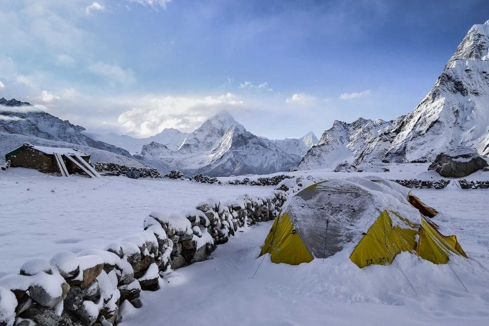 Snowy mountain valley with accent tents